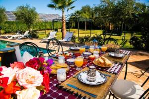a picnic table with food and orange juice on it at Villa Dar Saada in Marrakesh