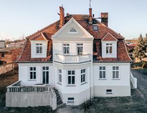 a white house with a red roof at Cloud Comfort Studio Willa Miejska Górka in Miejska Górka