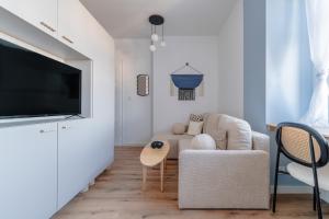 a living room with a couch and a tv at Cloud Comfort Studio Willa Miejska Górka in Miejska Górka