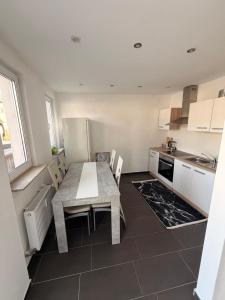 a kitchen with a table and chairs in a kitchen at Kleines Appartment mit großer Terrasse in Herscheid +3 photos