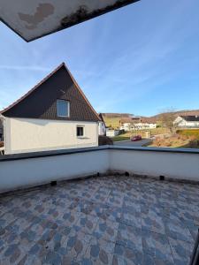 a balcony with a view of a house at Kleines Appartment mit großer Terrasse in Herscheid