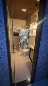 a bathroom with a toilet and a painting on the wall at Casa aconchegante com piscina e wi-fi rápido in Aracaju +14 photos