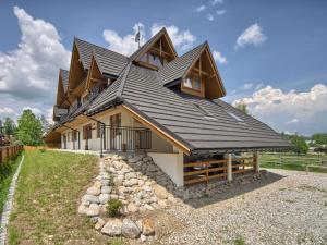 ein Haus mit einem Gamerleit-Dach darüber in der Unterkunft Willa Mnich in Zakopane