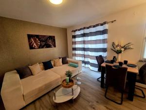 a living room with a white couch and a table at Ferienhaus am Tänntalbach in Öhrenfeld