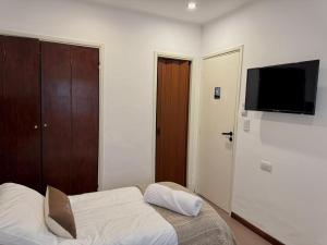 a bedroom with a bed and a flat screen tv at Hotel Hijos Del Mar - Rincón Costero in Miramar