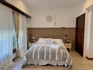 a bedroom with a bed with two night stands and a window at Hotel Hijos Del Mar - Rincón Costero in Miramar +17 photos