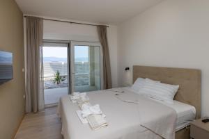 a bedroom with a large white bed with a balcony at Villa Sole in Komarna +33 photos