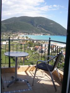 a table and a chair on a balcony with a view of the water at Katerina Lefkada in Vasiliki