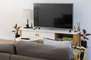 a living room with a couch and a large television at Lakes Edge 1 - 2BR Close to Lake in Wendouree