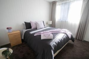 a bedroom with a bed with a pink bow on it at Lakes Edge 1 - 2BR Close to Lake in Wendouree