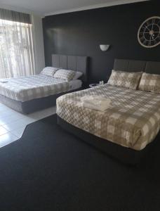a bedroom with two beds and a window at Yarrawonga Lakeside Apartment 31 in Mulwala +8 photos