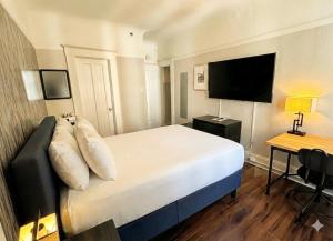 a hotel room with a bed and a flat screen tv at Hotel Ikon in San Francisco