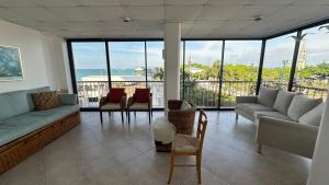 a living room with couches and chairs and windows at Departamento Frente al Salinas Yacht Club in Salinas