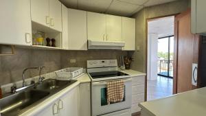 a kitchen with a sink and a stove top oven at Departamento Frente al Salinas Yacht Club in Salinas +8 photos