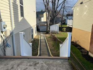 a driveway leading to a house with a white fence at 25 Lux Room 5 - 2 Queen Beds, Shared Bathroom - Nonsmoking in Arlington