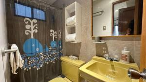 a bathroom with a yellow toilet and a sink at Departamento Frente al Salinas Yacht Club in Salinas