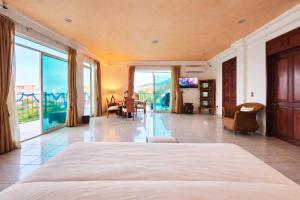 a bedroom with a large bed and a living room at Hillside Villa with ocean views in Puerto Vallarta
