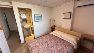 a small bedroom with a bed and a bathroom at Departamento Frente al Salinas Yacht Club in Salinas