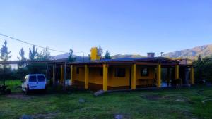 a yellow house with a van parked next to it at Barranca de la Luna in Tafí del Valle