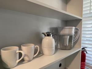 a shelf with three coffee cups and a blender at 25 Lux Room 5 - 2 Queen Beds, Shared Bathroom - Nonsmoking in Arlington