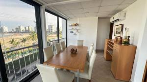 a kitchen with a table and chairs and a large window at Departamento Frente al Salinas Yacht Club in Salinas