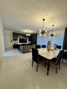 a dining room and living room with a table and chairs at Dominik luxury penthouse in Cancún