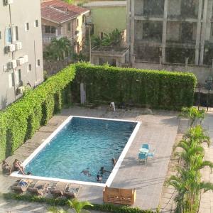 a swimming pool with people in the water at Appart Congo-Warf- vue mer in Pointe-Noire