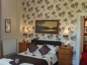 Un dormitorio con una cama y un cuadro en la pared. en Telford Manor House, en Beattock