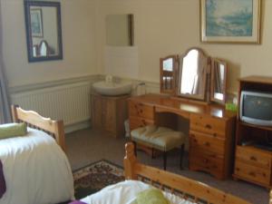 Un dormitorio con una cama, un lavabo y un espejo. en Telford Manor House, en Beattock