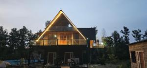 a house with a triangular roof with lights on it at Ambience Retreat in Malavalli