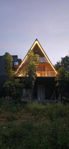a house sitting on top of a lush green field at Ambience Retreat in Malavalli