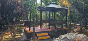 a gazebo in a garden with a tree at Ambience Retreat in Malavalli