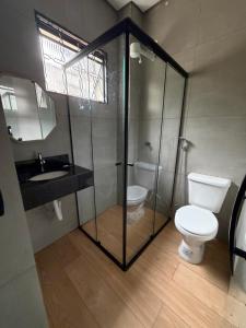 a bathroom with a glass shower and a toilet at Hotel Pousada Romanos in Aparecida +38 photos
