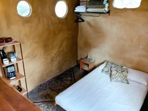 a bedroom with a bed in a room with two windows at BioChalé Buena Vista in Sao Jorge