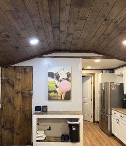 a kitchen with a painting of a cow on the wall at The Cozy Cow Cottage in Bluefield +9 photos