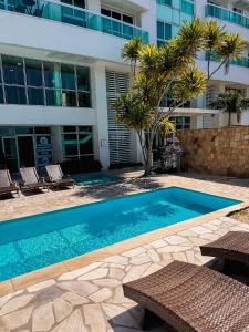 a swimming pool in front of a building at FLAT MANDAI Praia do Forte - Cabo Frio - RJ in Cabo Frio