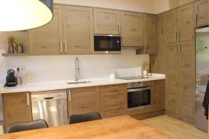 a kitchen with wooden cabinets and a table with chairs at Casa Dula in Pla de l'Ermita