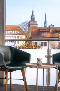 a table and chair on a balcony with a view of a city at Modernes Altstadt-Juwel in Buchen