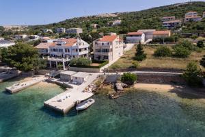 an aerial view of a house with a boat in the water at Apartmani Kaštel in Stara Novalja