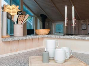 a table with mugs and candles on a counter at 6 person holiday home in Toftlund-By Traum in Toftlund +27 photos