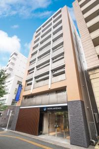 een hoog gebouw met een bord erop bij HOTEL MYSTAYS Kanda in Tokyo