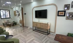 a living room with a flat screen tv on a wall at Niu Homestay in An Khê