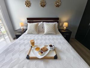 a bed with a tray of food on it at Hotel GM zamora Balcony in Zamora