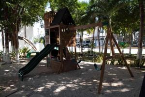 a playground with a slide in a park at Casa Atardecer - Privada Los Olivos in Playa del Carmen