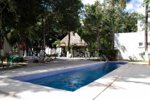 a blue swimming pool with a gazebo and trees at Casa Atardecer - Privada Los Olivos in Playa del Carmen