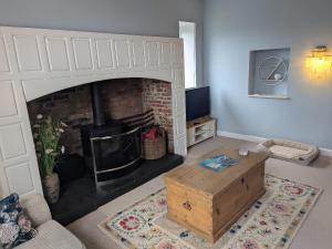 a living room with a fireplace with a couch and a table at Glebe Garth in Ventnor
