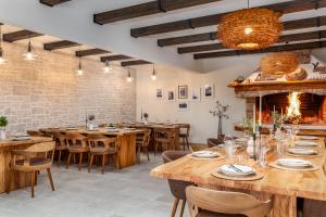 a restaurant with wooden tables and chairs and a fireplace at Camp Panorama with pool in Drage