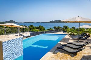 a swimming pool with chairs and umbrellas at Camp Panorama with pool in Drage