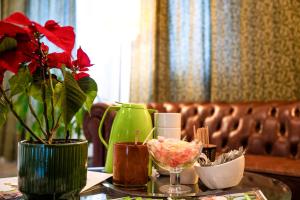 a table with a green vase with a plant on it at Hotel ANNA - Düsseldorf - Hilden in Hilden