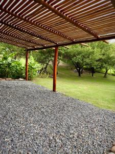 a large pile of gravel under a wooden pergola at Casas de campo Traslasierra in Villa Cura Brochero